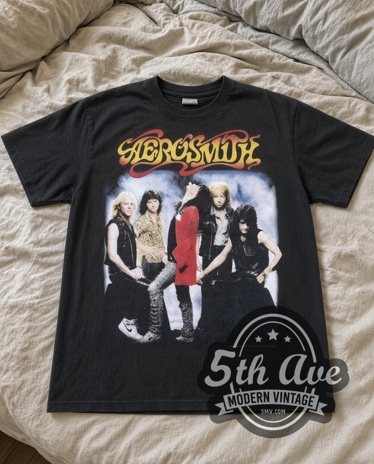 Aerosmith Band Photo vintage band t-shirt in black laid flat on a bed, front artwork