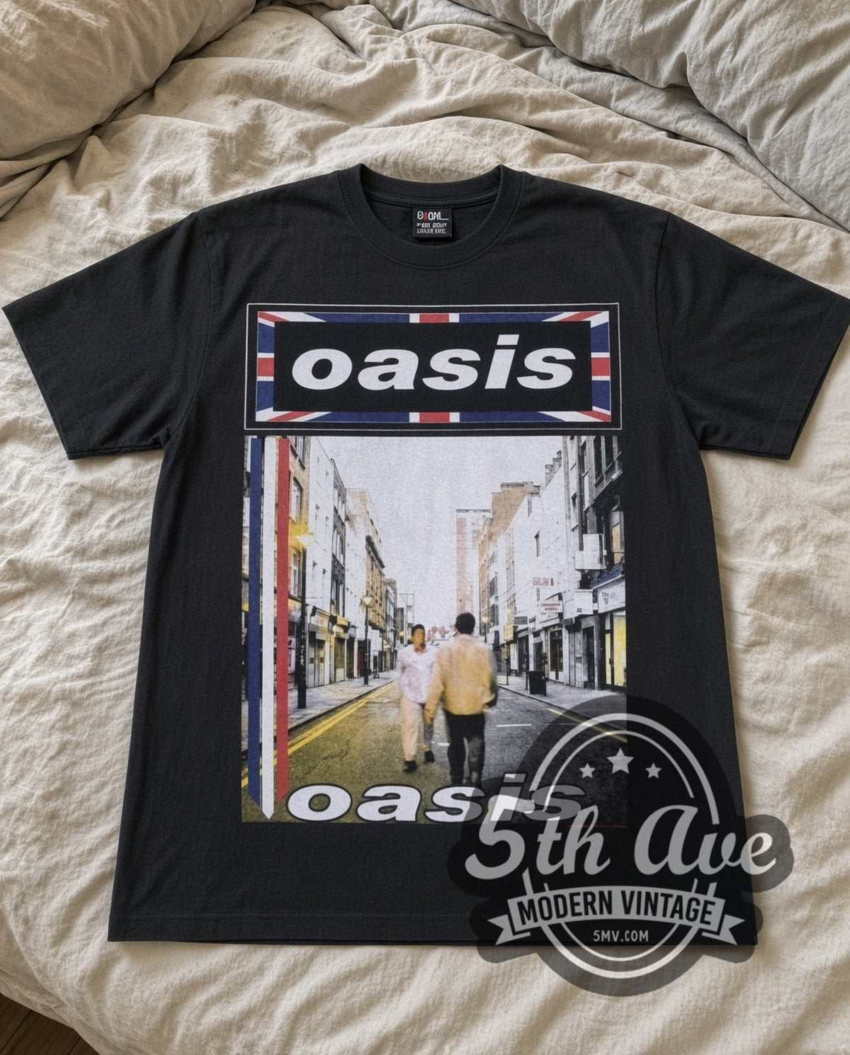 Oasis Street vintage band t-shirt in black laid flat on a bed, front artwork
