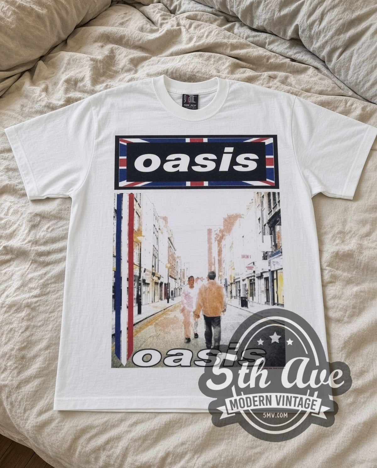 Oasis Street vintage band t-shirt in white laid flat on a bed, front artwork