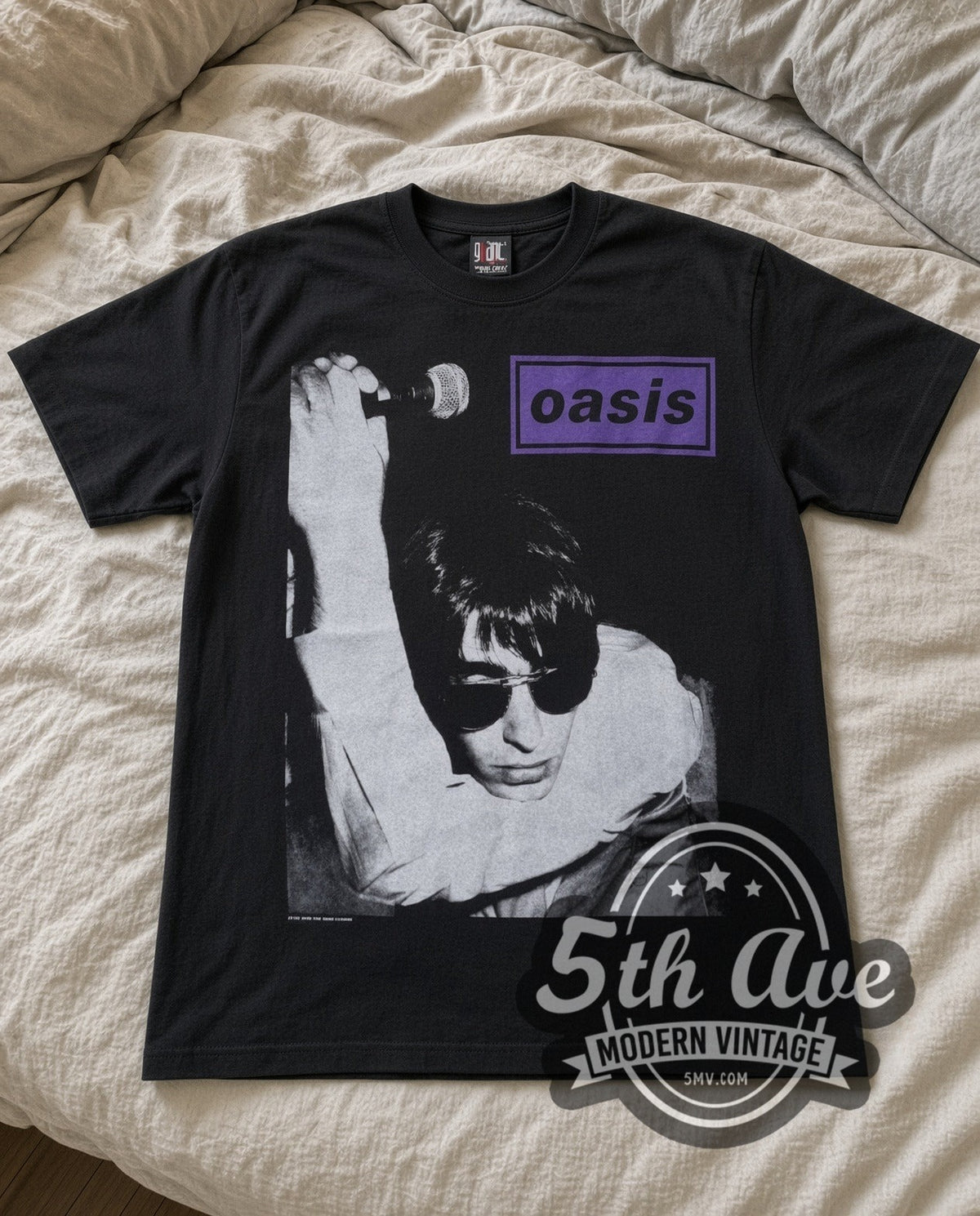Oasis Liam Mic vintage band t-shirt in black laid flat on a bed, front artwork