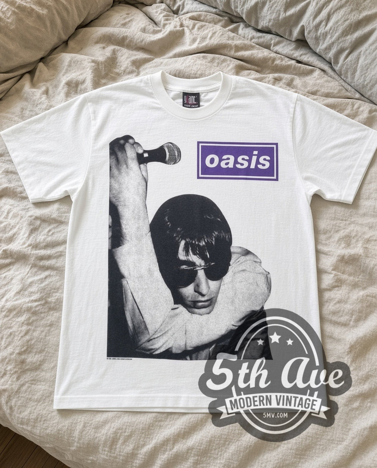 Oasis Liam Mic vintage band t-shirt in white laid flat on a bed, front artwork