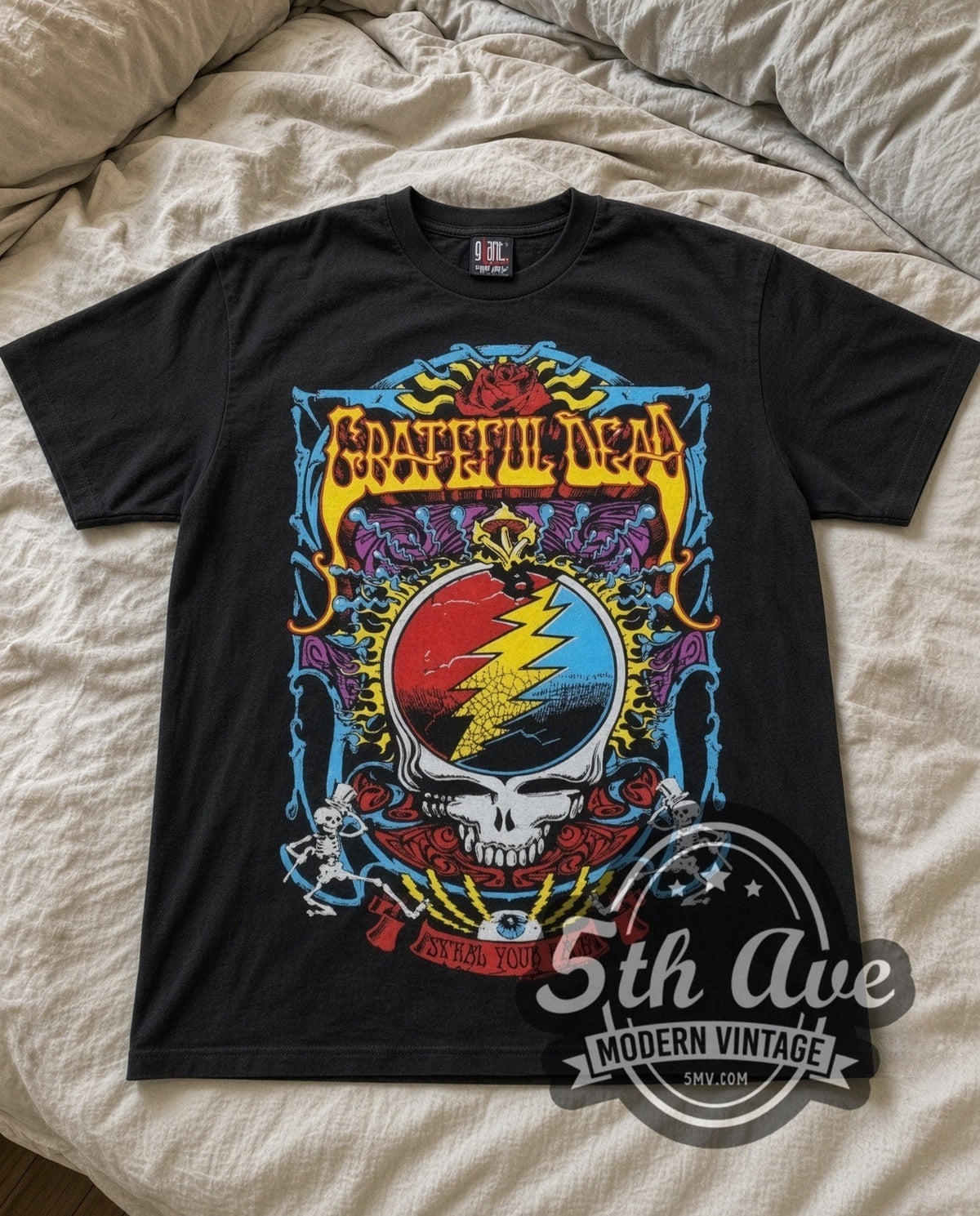 Grateful Dead Steal Your Face vintage band t-shirt in black laid flat on a bed, front artwork