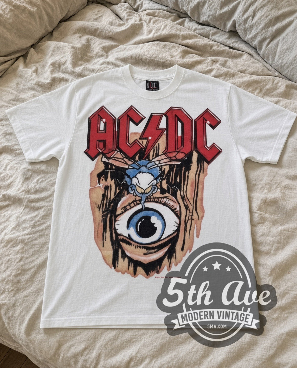 AC/DC Stitched Eye vintage band t-shirt laid flat on a bed, front artwork