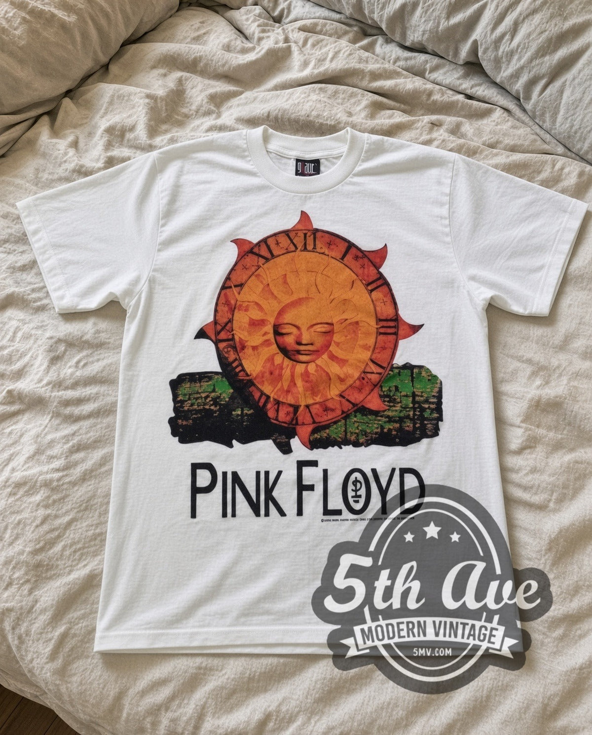 Pink Floyd Sun vintage band t-shirt in white laid flat on a bed, front artwork