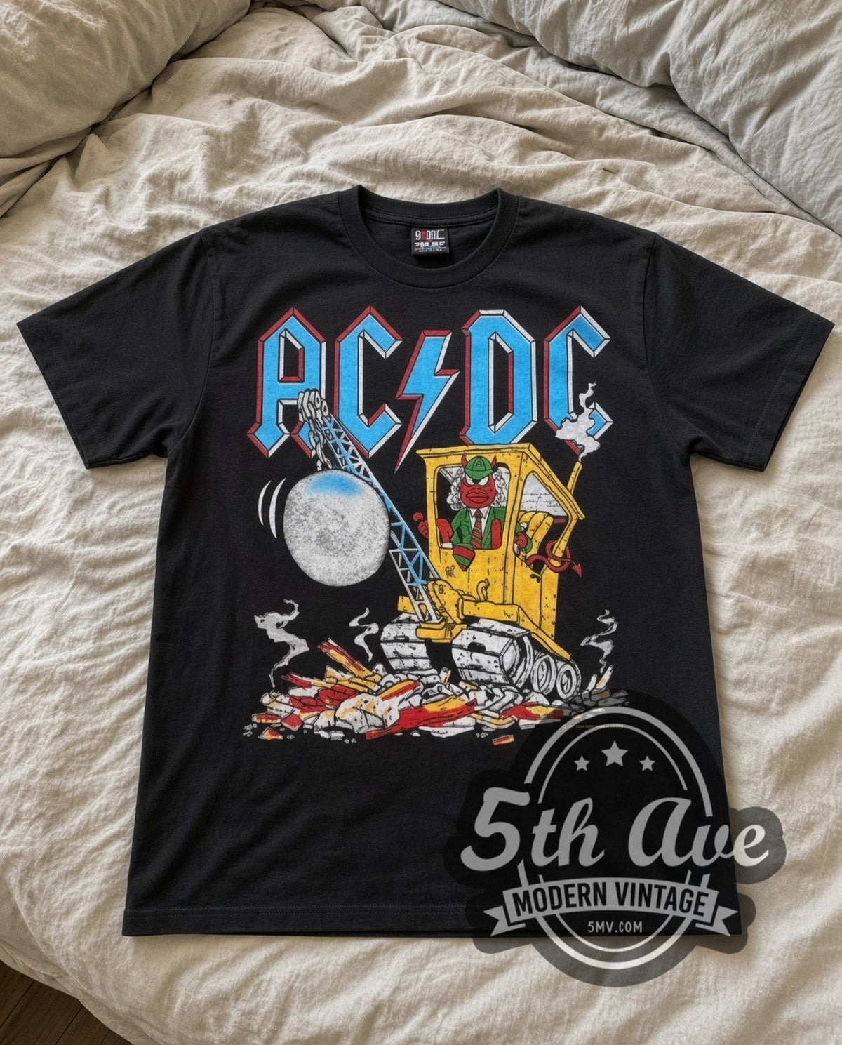 AC/DC Cannon vintage band t-shirt in black laid flat on a bed, front artwork
