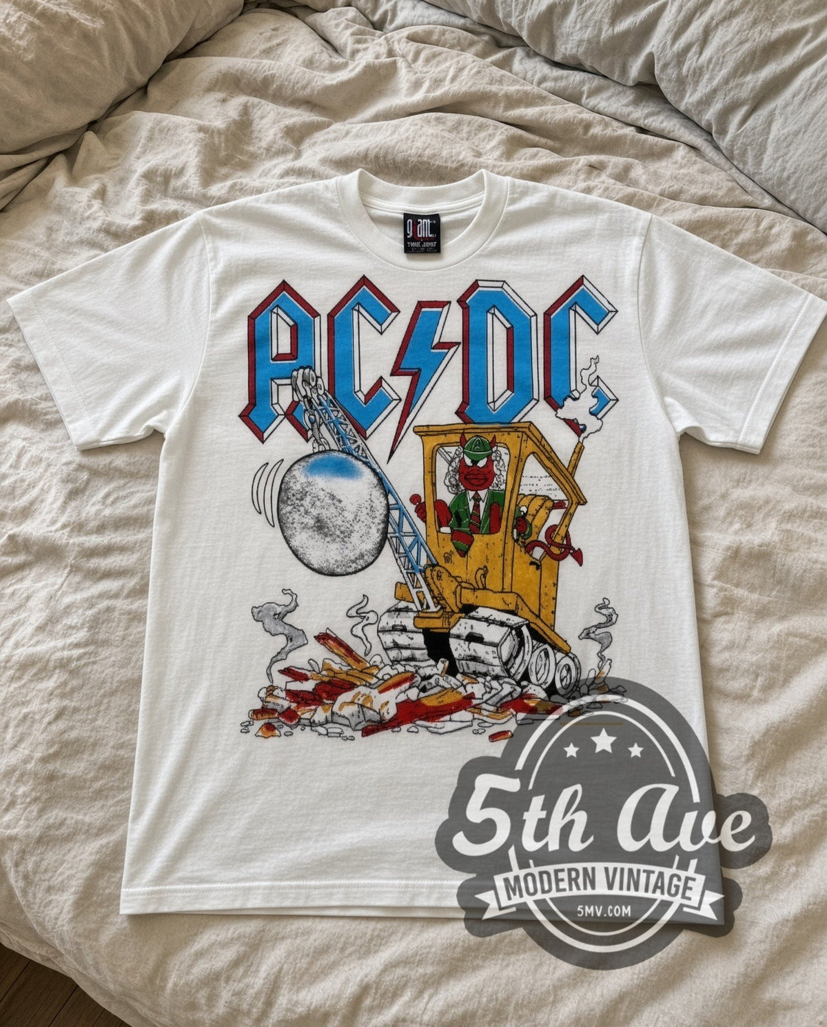 AC/DC Cannon vintage band t-shirt in white laid flat on a bed, front artwork
