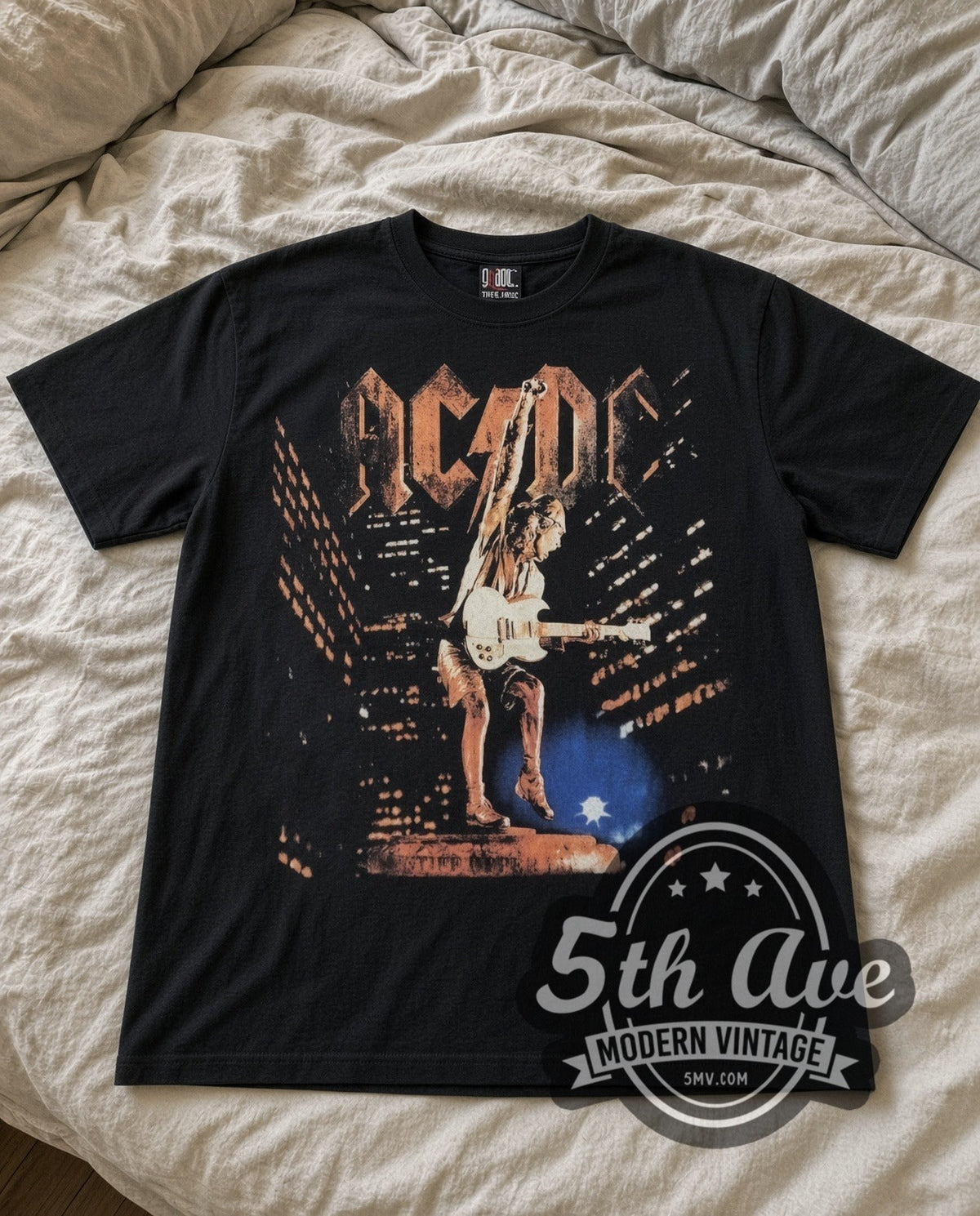 AC/DC Angus Live vintage band t-shirt in black laid flat on a bed, front artwork