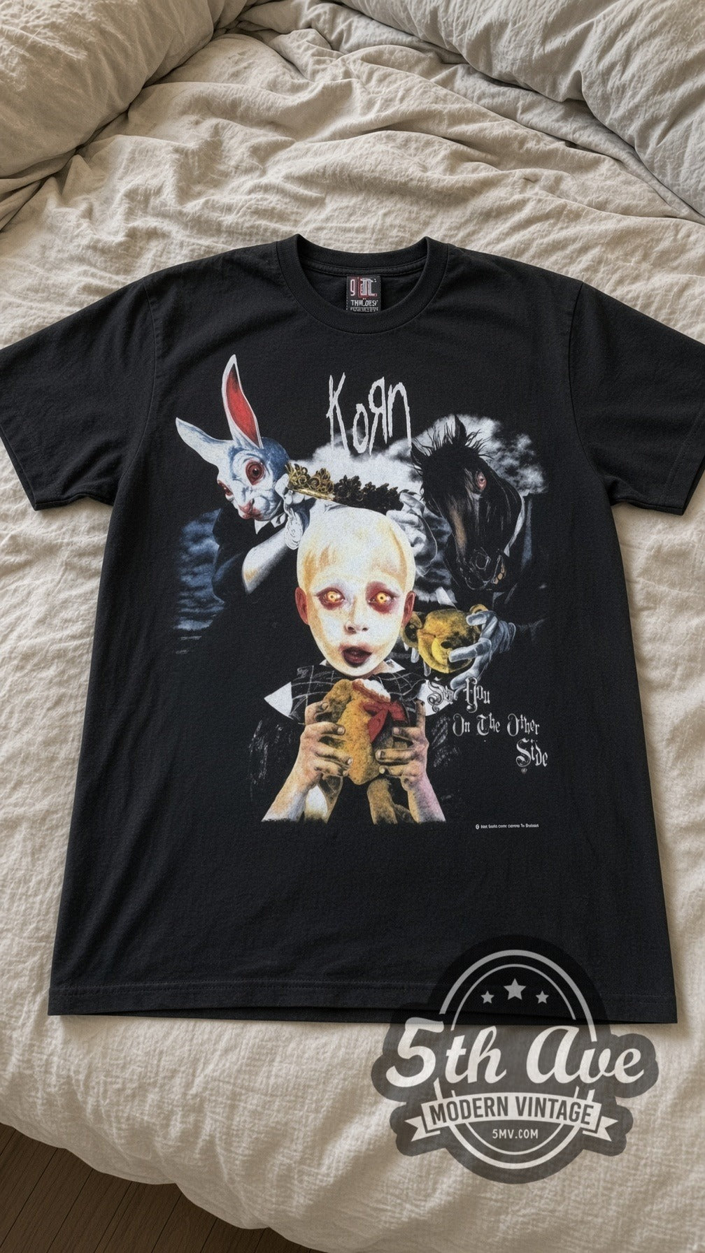 Korn Bunny Doll vintage band t-shirt in black laid flat on a bed, front artwork