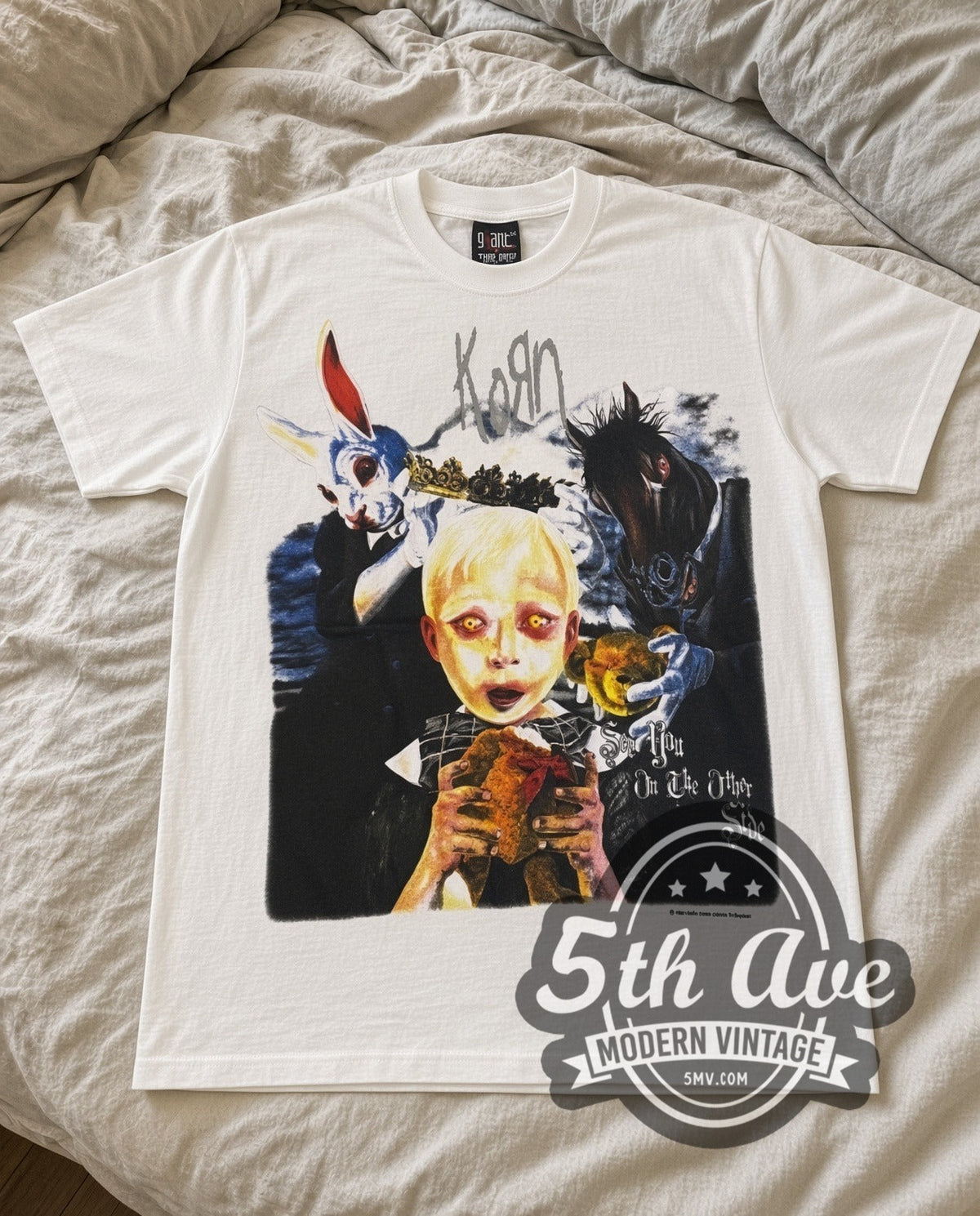 Korn Bunny Doll vintage band t-shirt in white laid flat on a bed, front artwork
