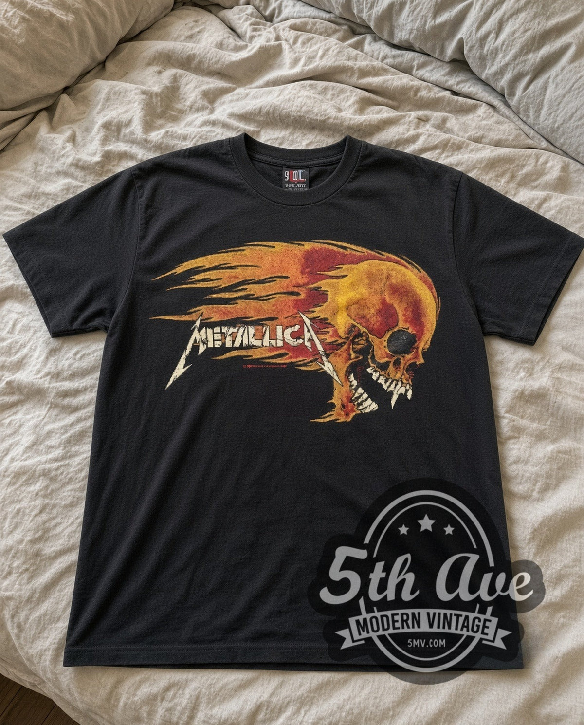 Metallica Flaming Skull vintage band t-shirt laid flat on a bed, front artwork