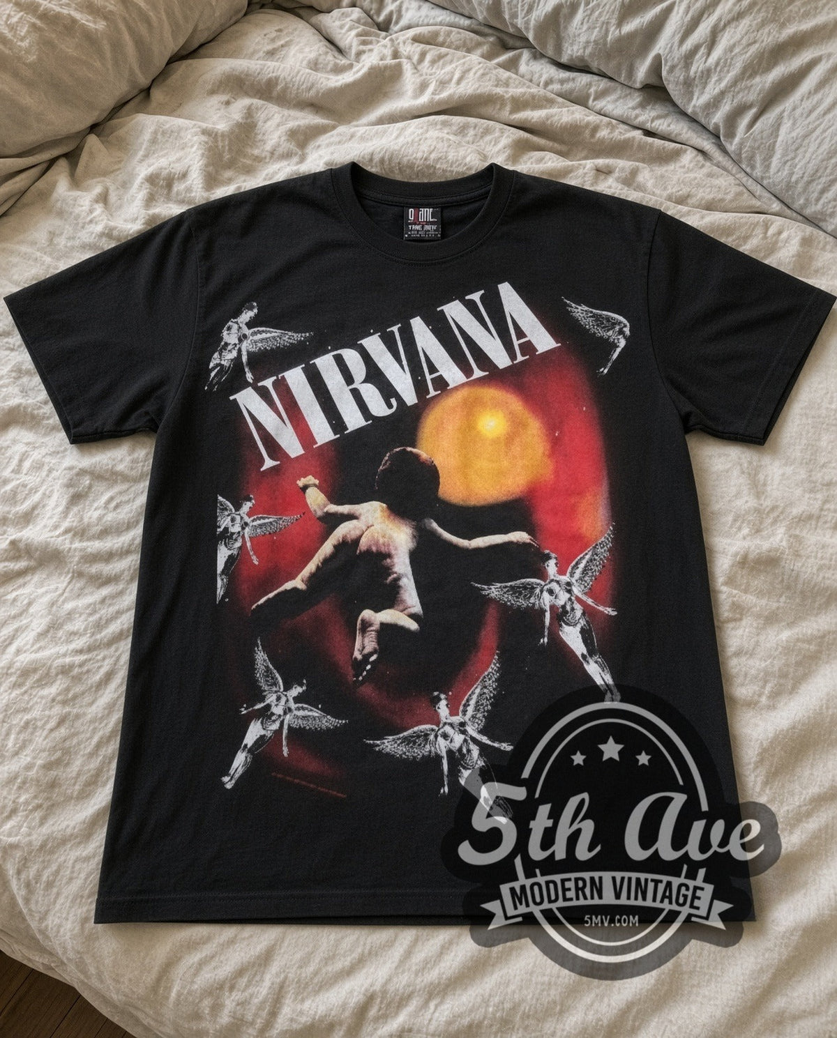 Nirvana Orange Moon vintage band t-shirt in black laid flat on a bed, front artwork