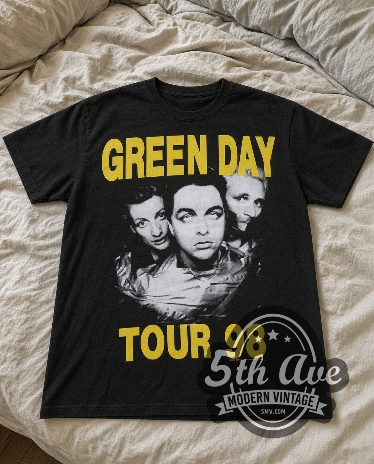 Green Day Tour 98 vintage band t-shirt in black laid flat on a bed, front artwork