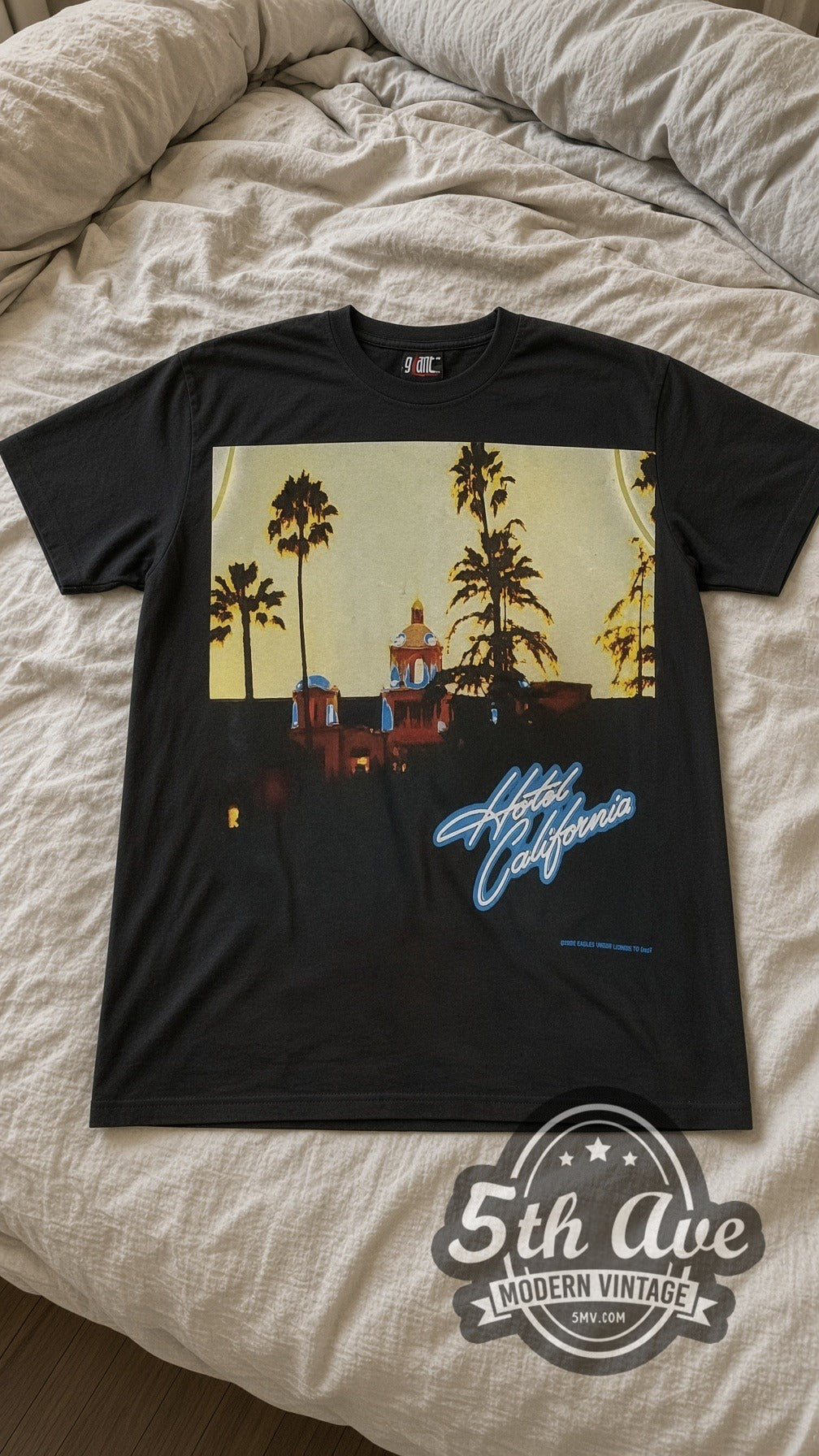 Eagles Hotel Sign vintage band t-shirt laid flat on a bed, front artwork
