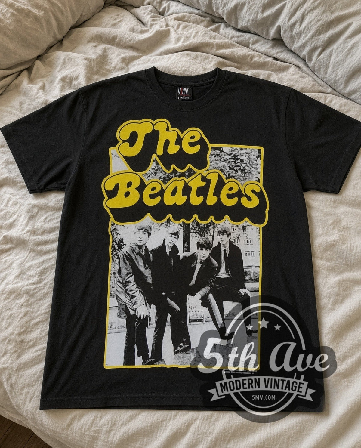The Beatles Cartoon Band vintage band t-shirt in black laid flat on a bed, front artwork