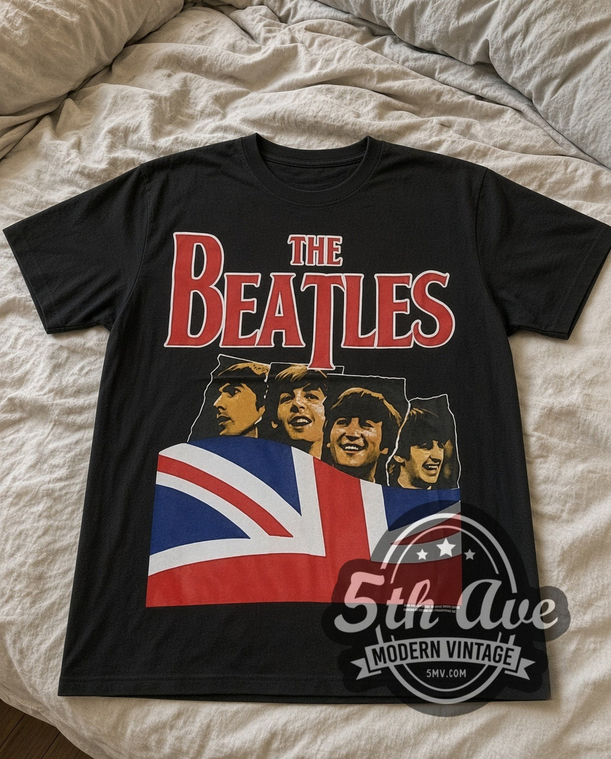 The Beatles Union Jack vintage band t-shirt in black laid flat on a bed, front artwork