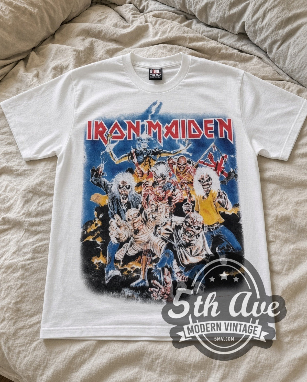 Iron Maiden Character Collage vintage band t-shirt in white laid flat on a bed, front artwork