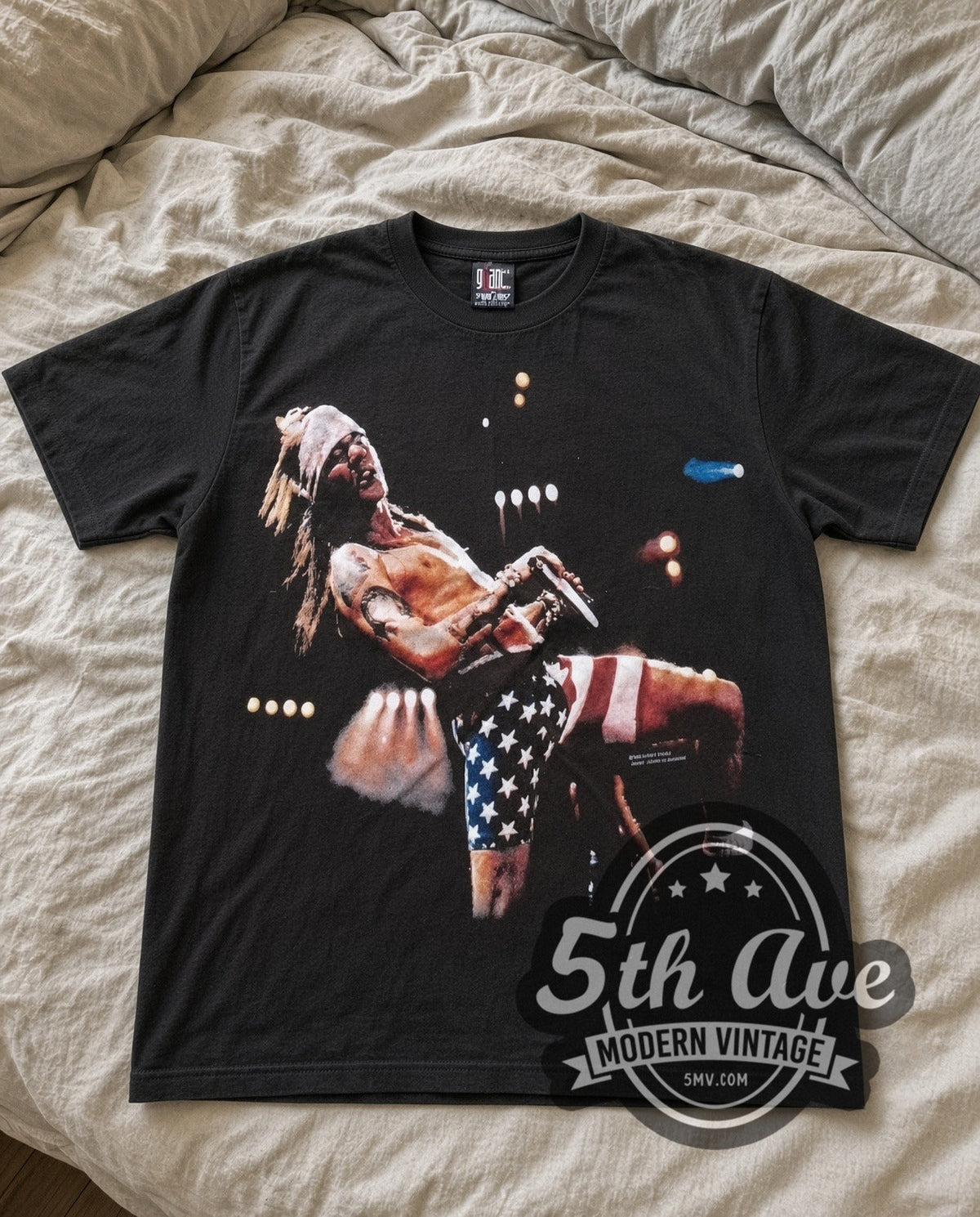 Guns N Roses Axl Flag vintage band t-shirt laid flat on a bed, front artwork