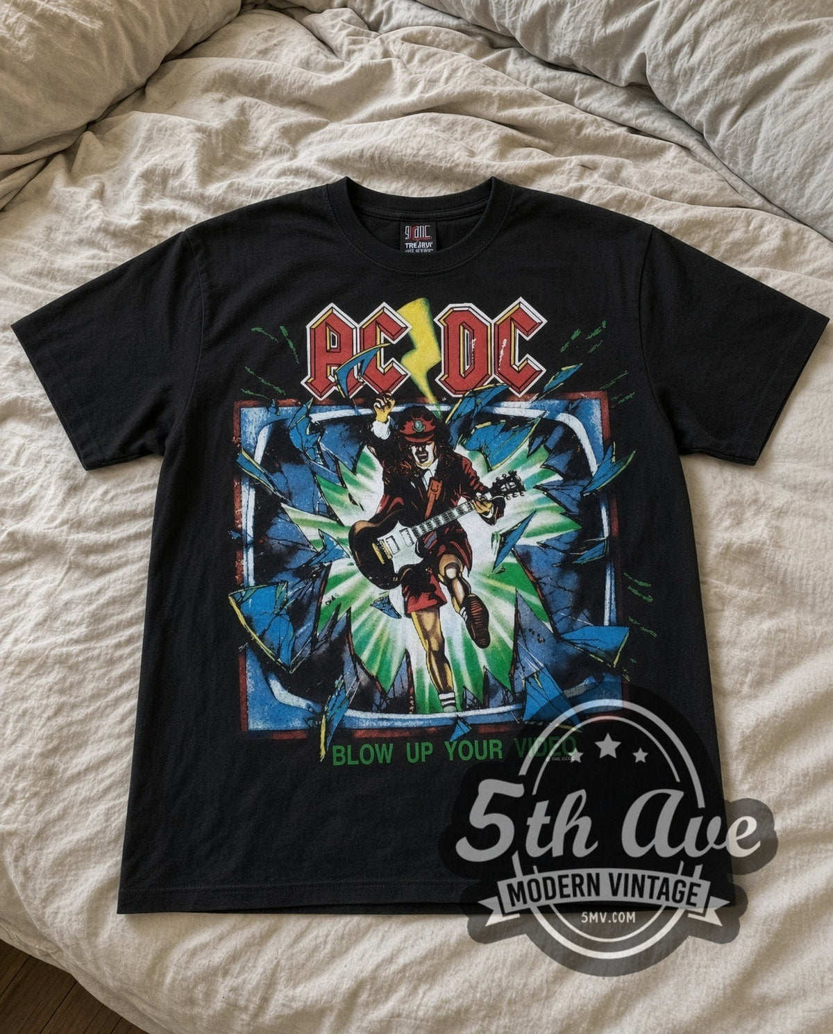 AC/DC Blow Up Your Video vintage band t-shirt in black laid flat on a bed, front artwork