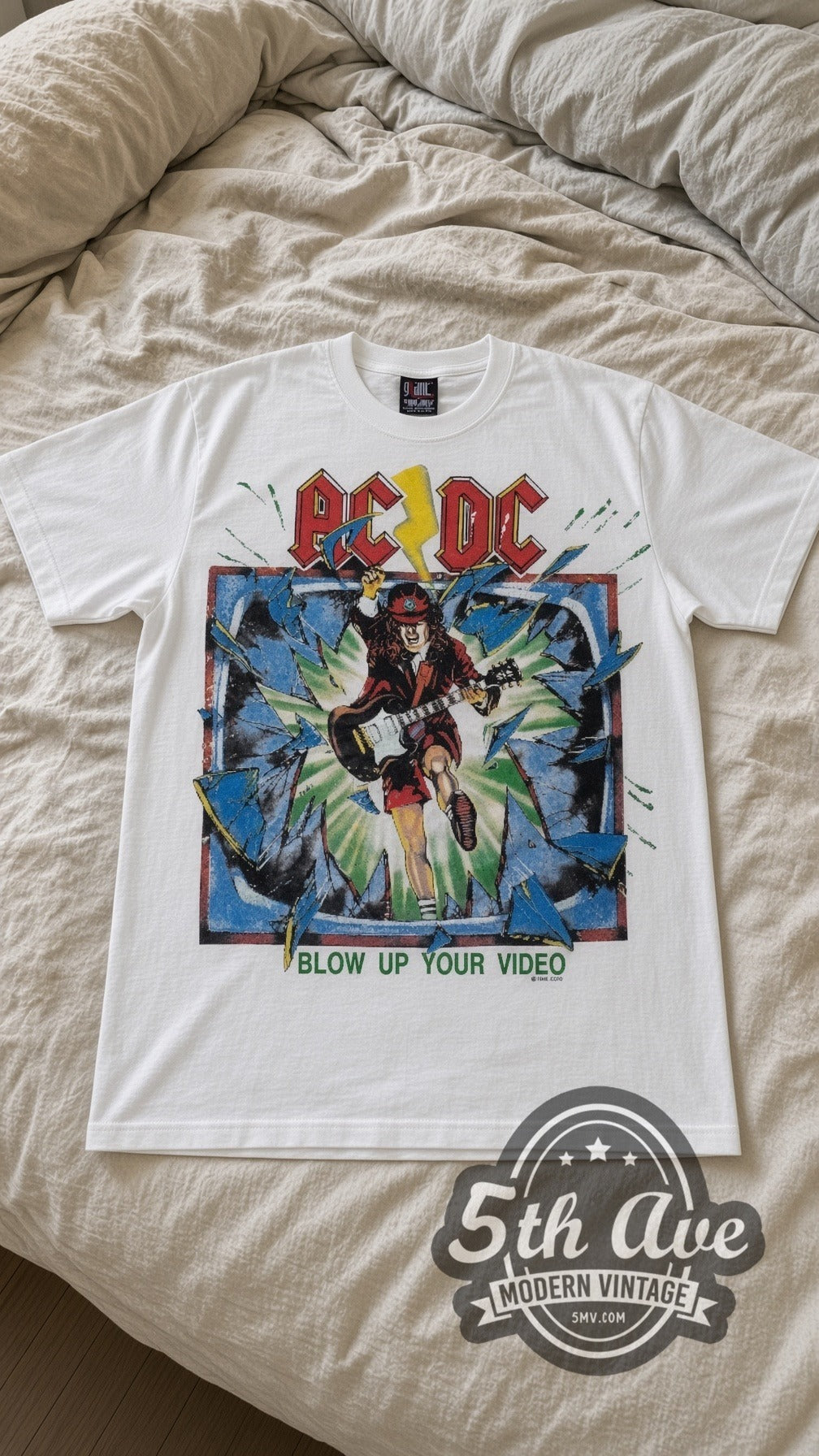 AC/DC Blow Up Your Video vintage band t-shirt in white laid flat on a bed, front artwork