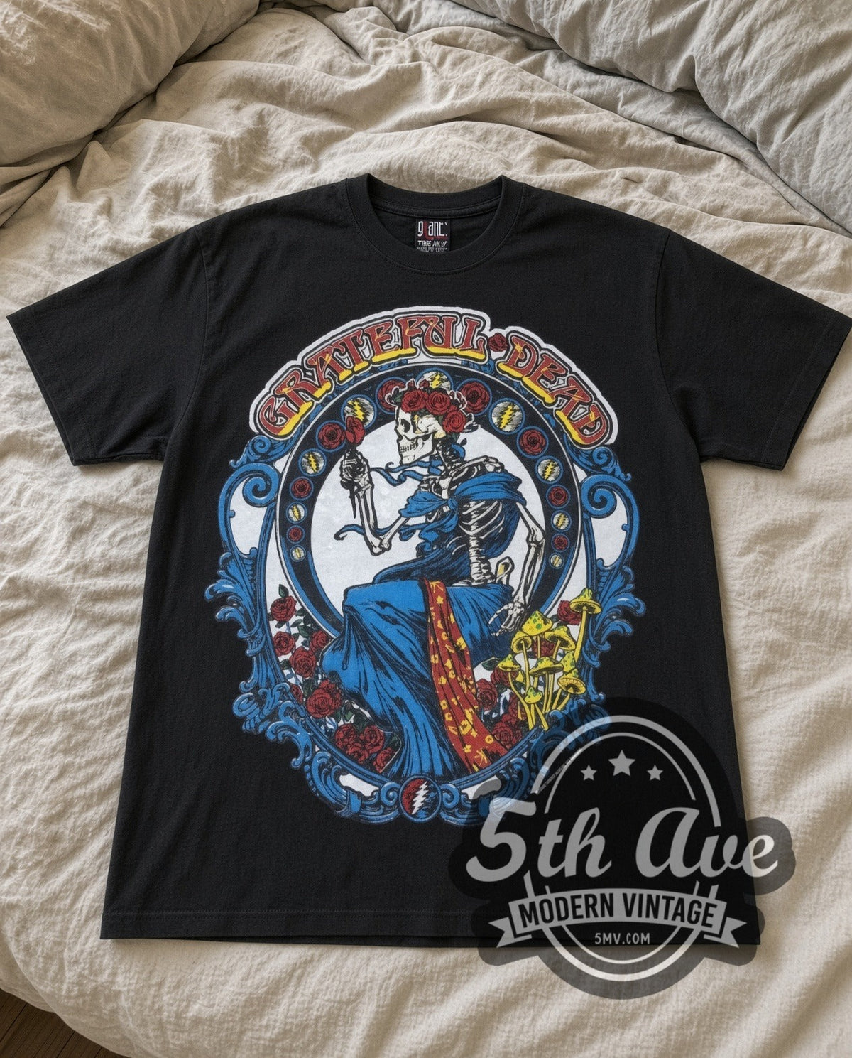 Grateful Dead Skeleton Bertha vintage band t-shirt in black laid flat on a bed, front artwork