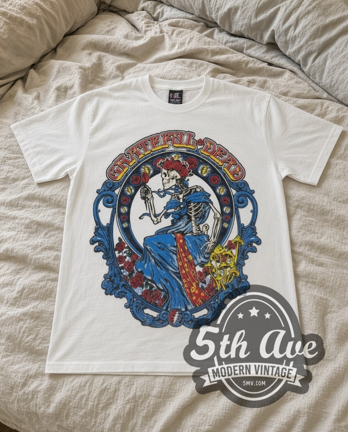 Grateful Dead Skeleton Bertha vintage band t-shirt in white laid flat on a bed, front artwork