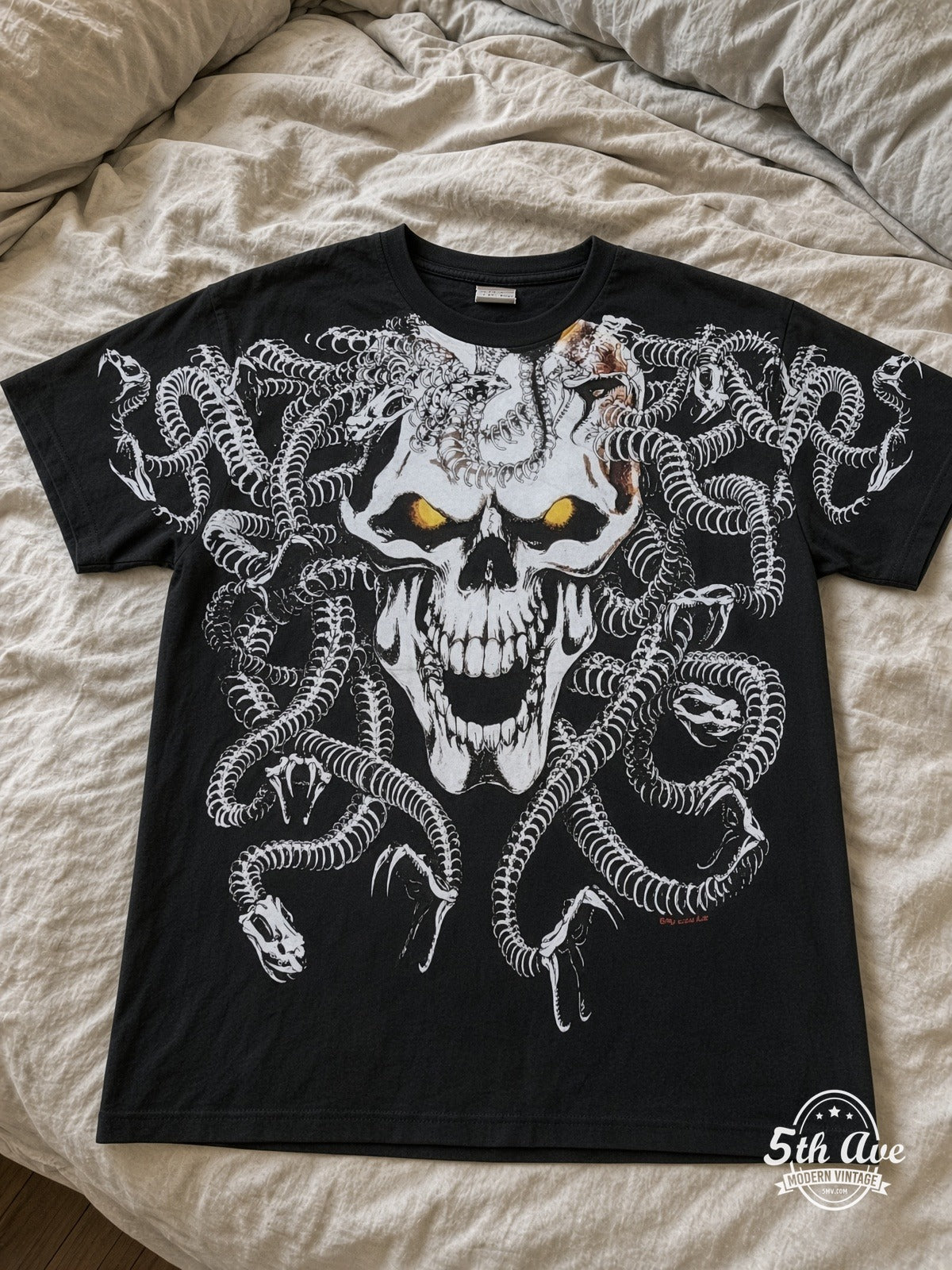 Medusa Snake Skull all over print vintage tee laid on bed