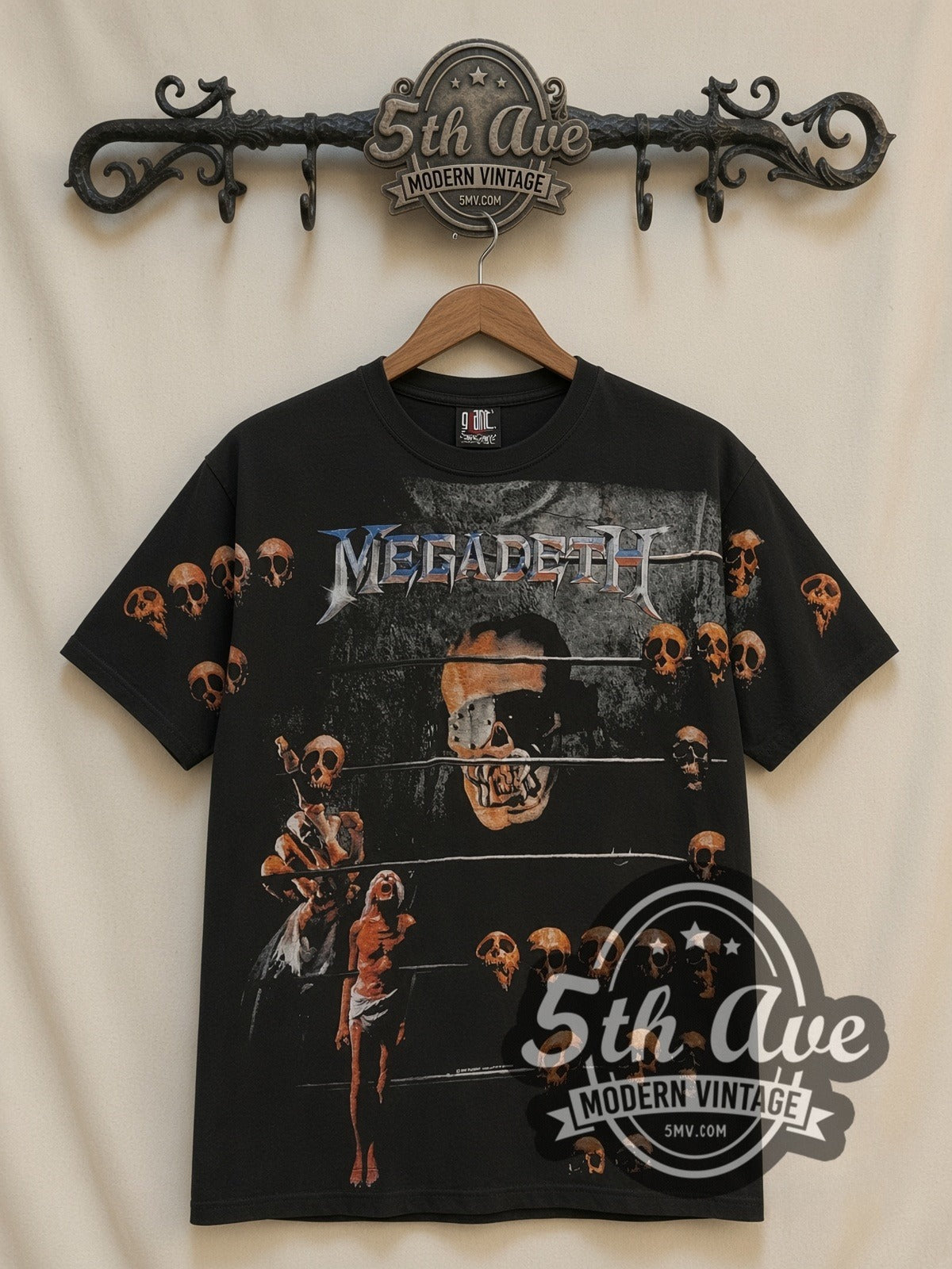 Megadeth Vic Prison Bars Skulls all-over-print vintage band t-shirt in black, front view on a display rack
