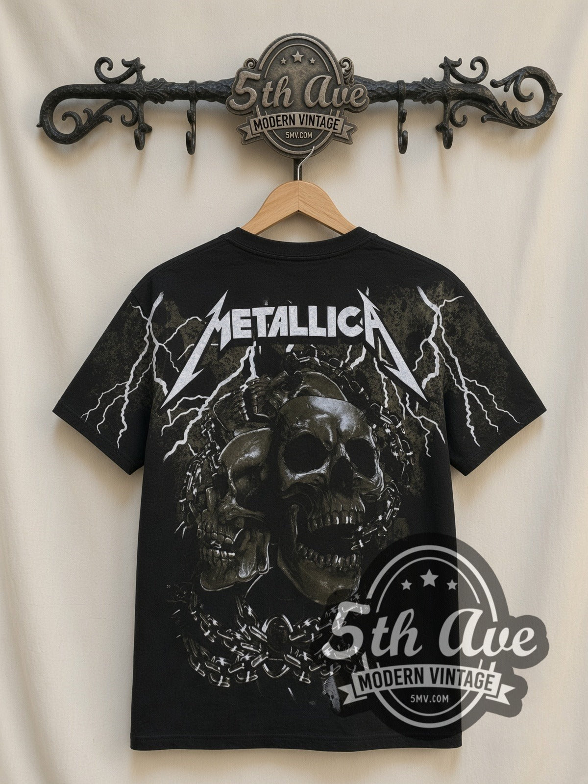 Metallica 40 Years Lady Justice all-over-print vintage band t-shirt in black, back view on a display rack