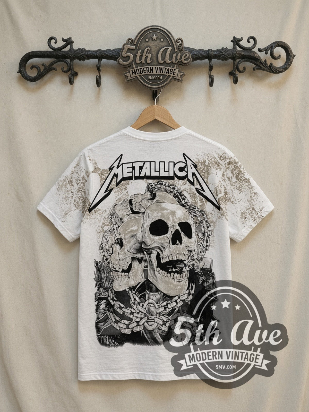 Metallica 40 Years Lady Justice all-over-print vintage band t-shirt in white, back view on a display rack