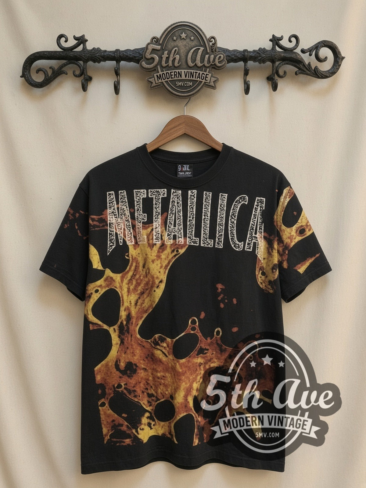 Metallica Liquid Fire all-over-print vintage band t-shirt in black, front view on a display rack