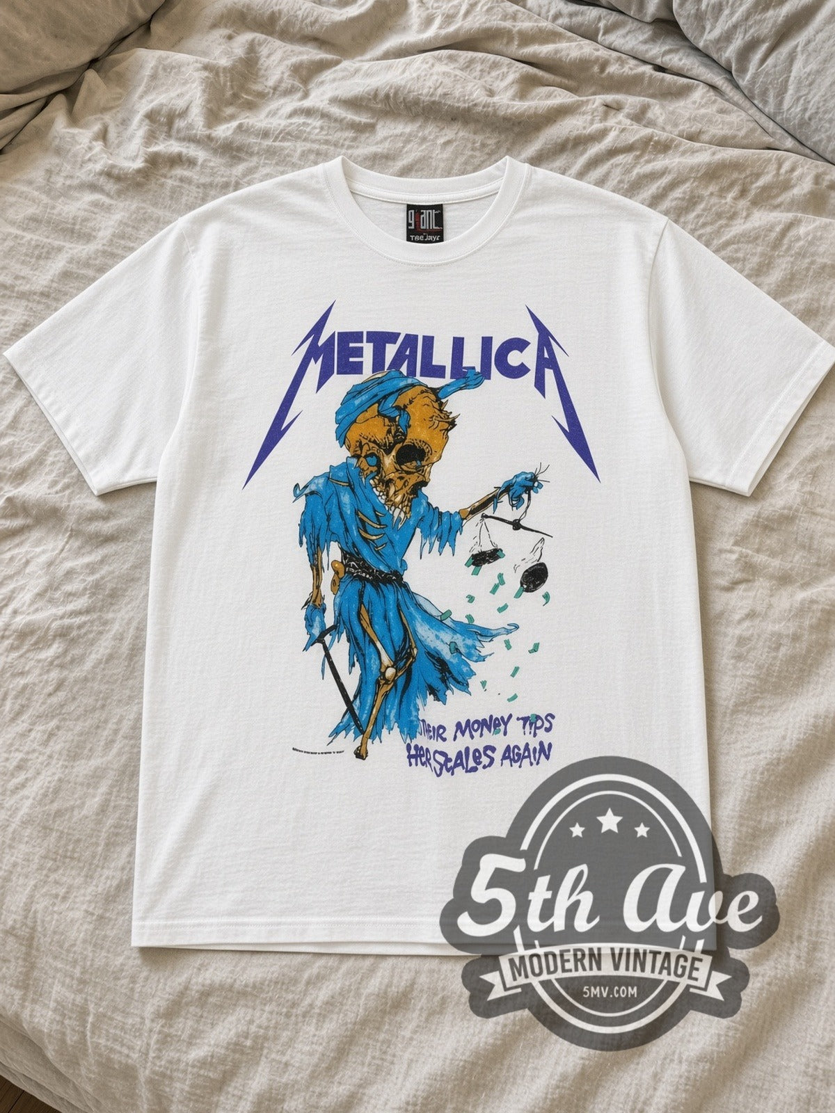 White Metallica Their Money Tips Her Scales Again Vintage Band T-Shirt laid flat on a linen bed