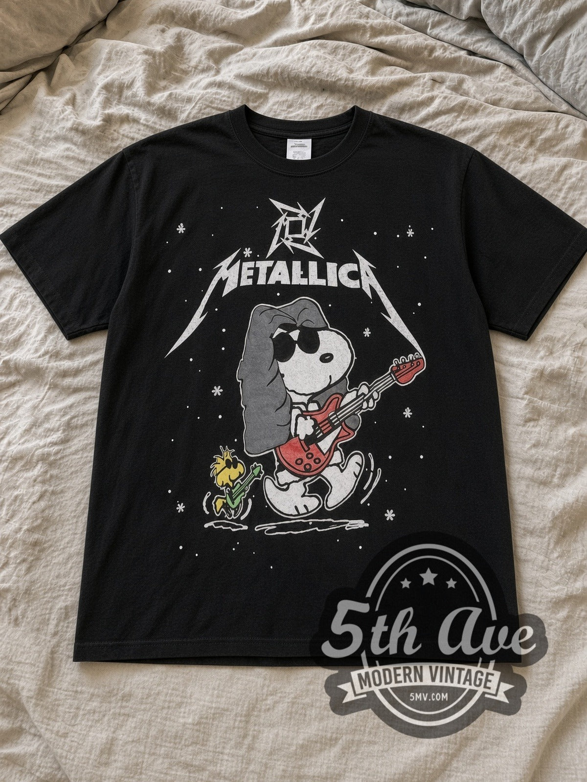 Black Peanuts Metallica x Snoopy Vintage Cartoon T-Shirt laid flat on a linen bed