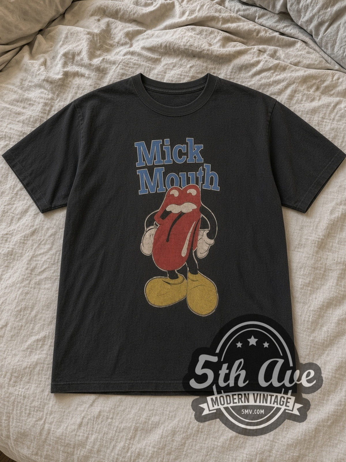 Black McMouth Iconic Lips Logo Vintage Band T-Shirt laid flat on a linen bed