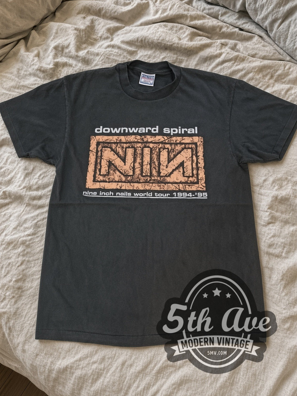 Faded black Nine Inch Nails Downward Spiral tour tee laid flat on linen bed