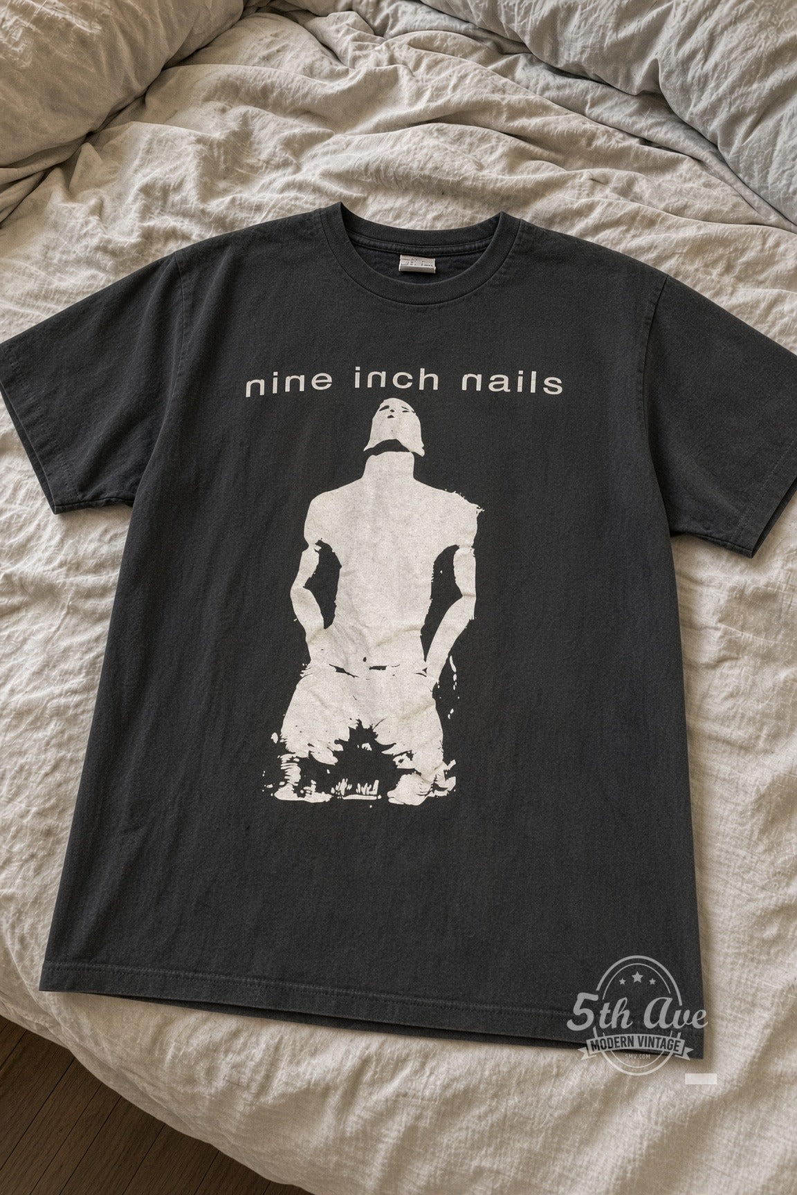 Nine Inch Nails Kneeling Figure NIN Logo vintage tee laid flat on bed