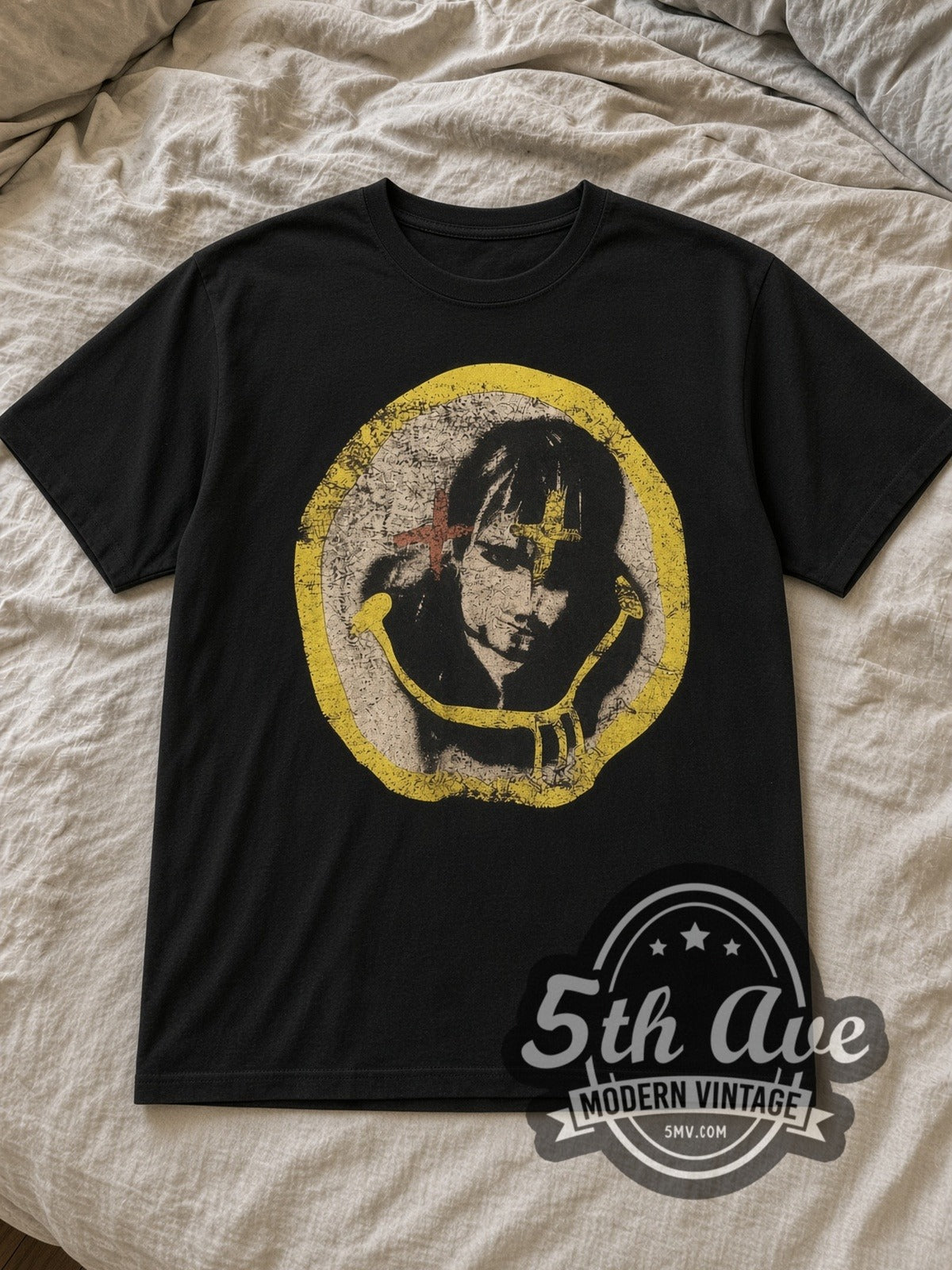 Black Nirvana Kurt Cobain Cross Eyes Yellow Circle Portrait Vintage Band T-Shirt laid flat on a linen bed