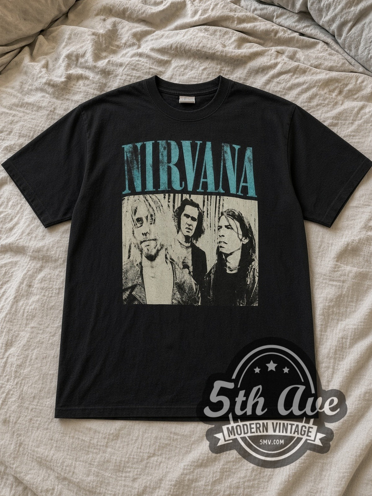 Black Nirvana Teal Logo Band Trio Photo Vintage Band T-Shirt laid flat on a linen bed