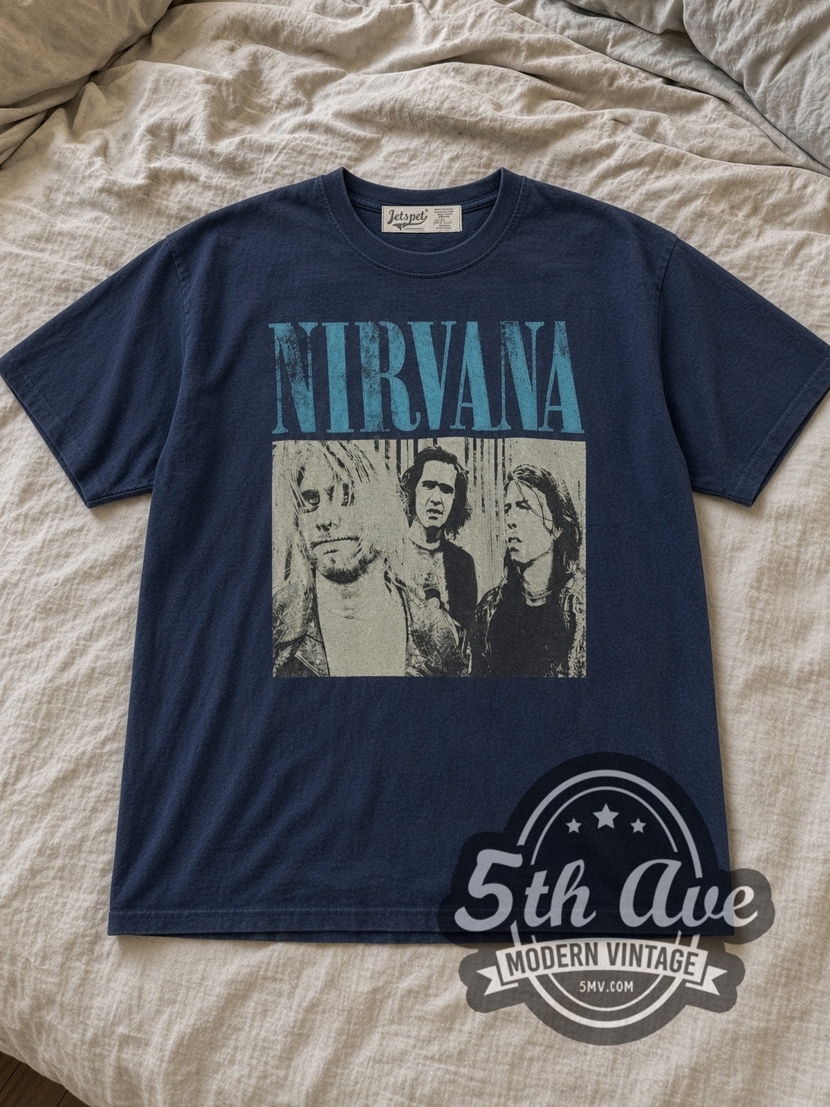 Navy Nirvana Aqua Logo High Contrast Trio Vintage Band T-Shirt laid flat on a linen bed