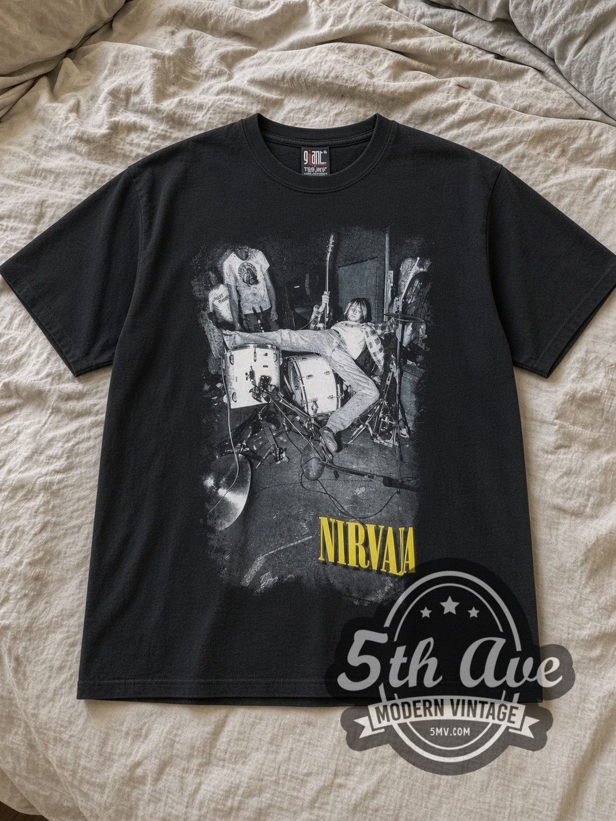 Black Nirvana Kurt Cobain Drum Jump Live Vintage Band T-Shirt laid flat on a linen bed