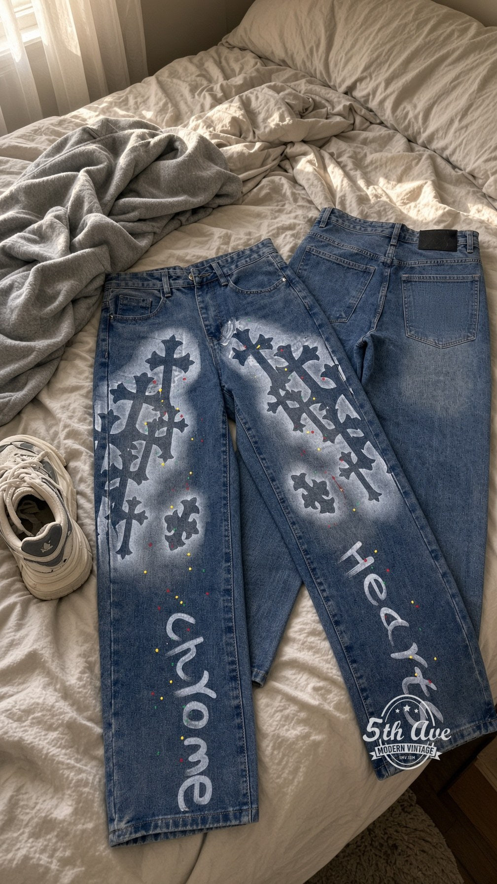 Gothic Cross Spray Paint Jeans laid on bed
