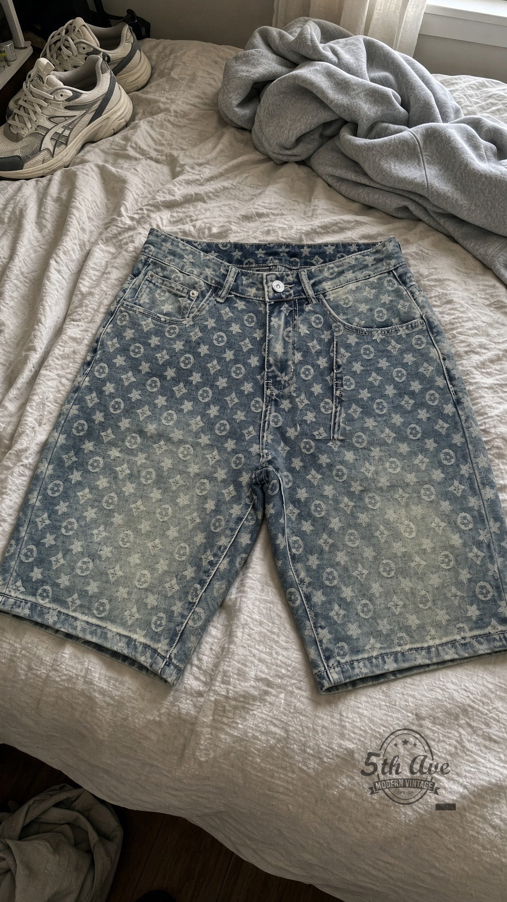 Dirty Wash Star Monogram Jorts laid on bed