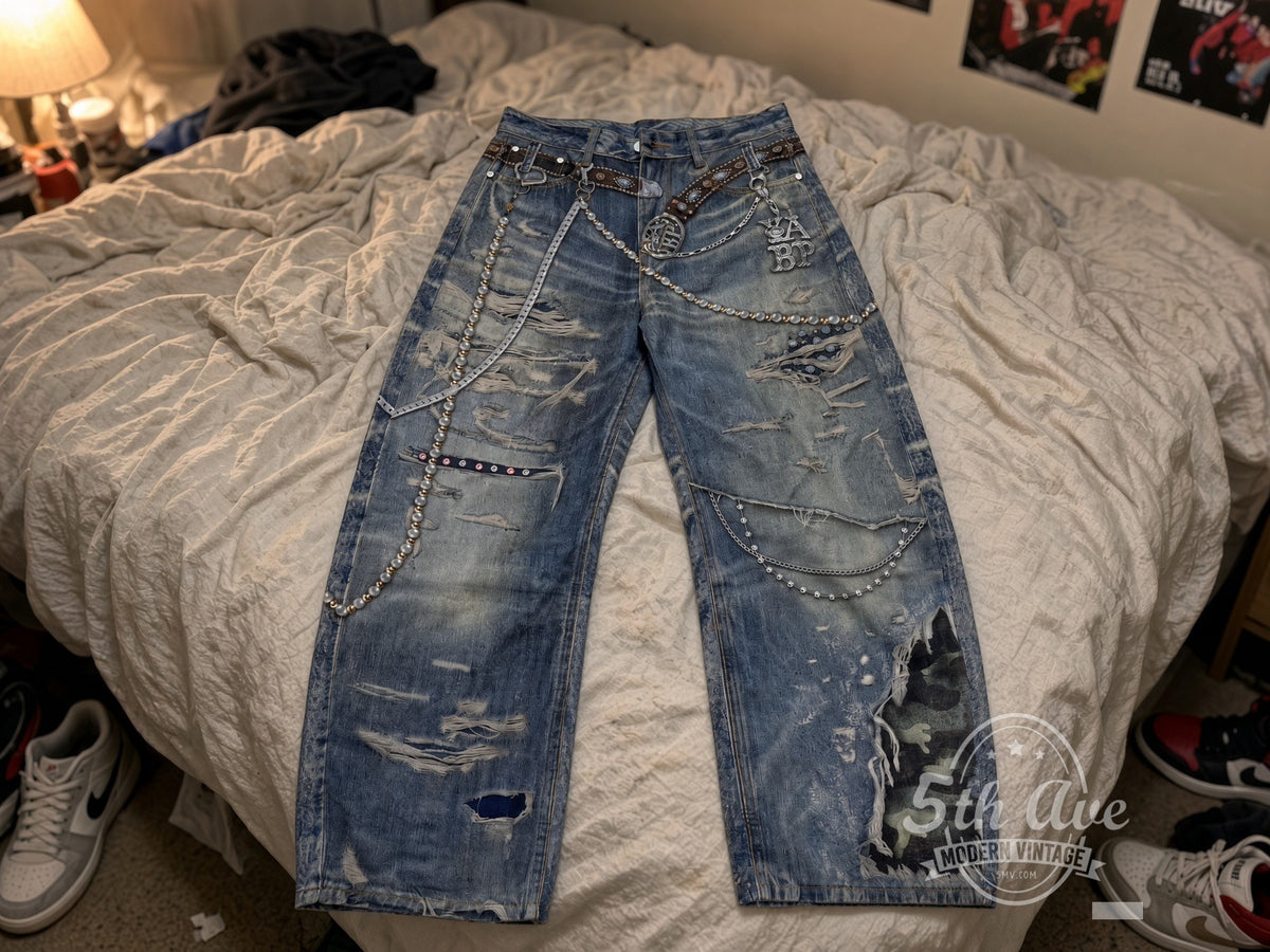 Distressed Pearl Chain Camo Patch Jeans laid on bed