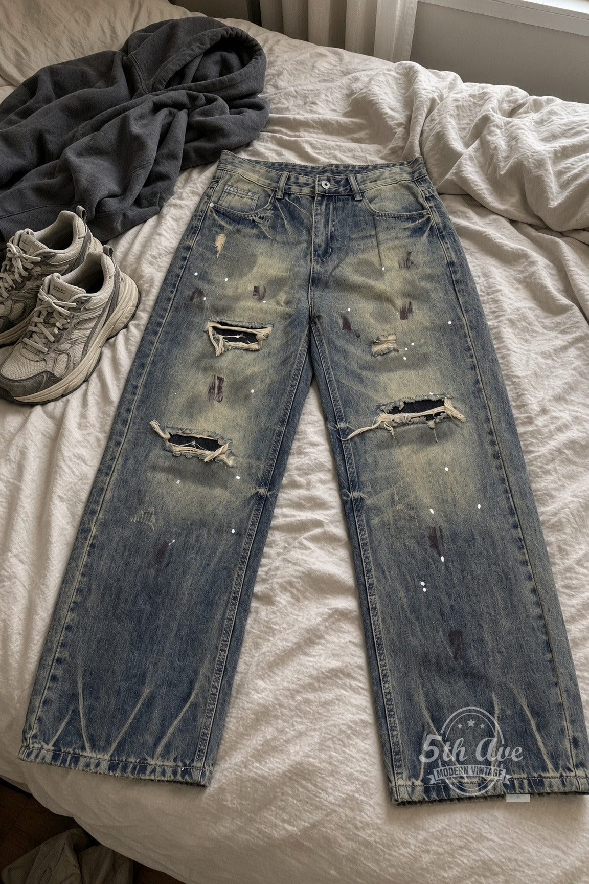 Dirty Wash Paint Splatter Zigzag Hem Jeans laid on bed