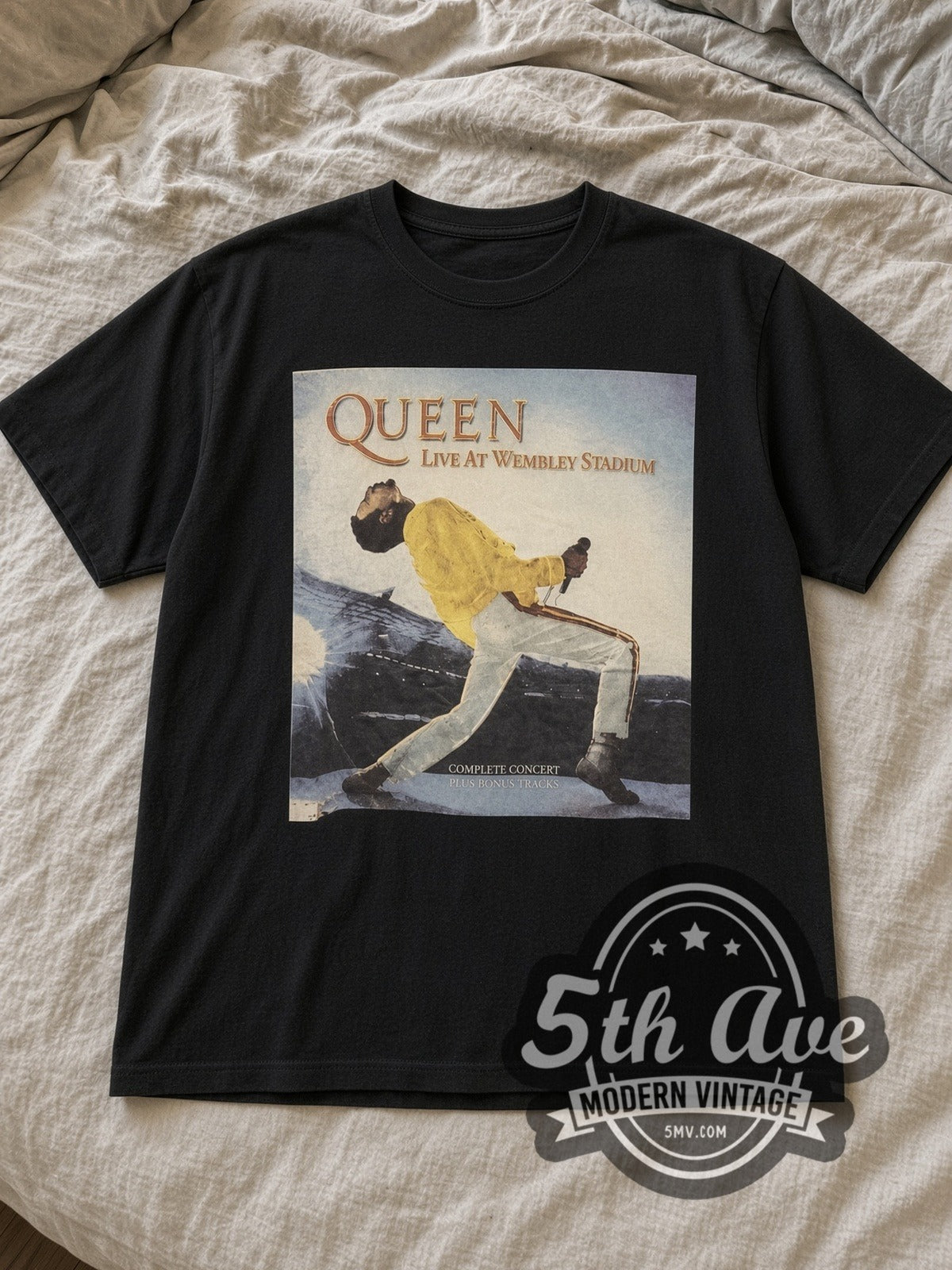 Black Queen Live at Wembley Stadium Vintage Band T-Shirt laid flat on a linen bed