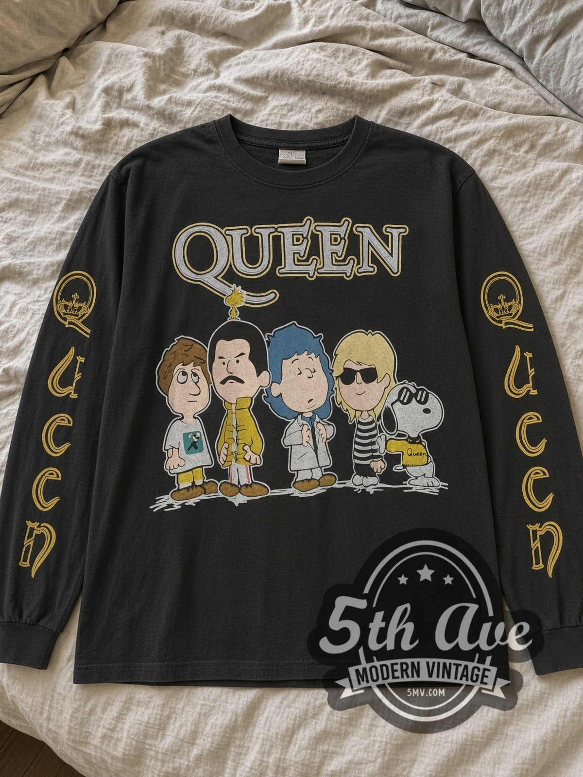 Black Queen x Peanuts long sleeve with Queen crest sleeves laid flat on linen bed
