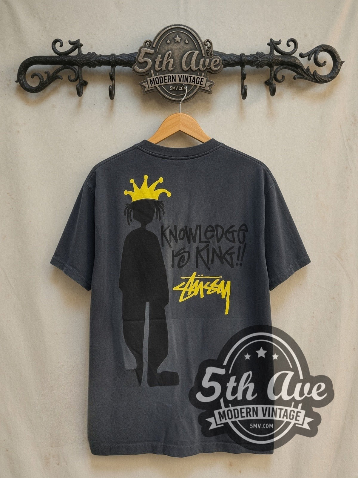 Stussy Knowledge Is King vintage graphic tee in black, back view on a display rack