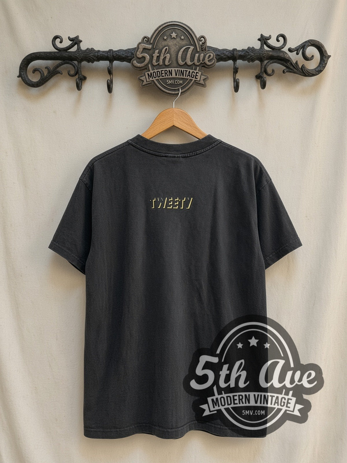 Looney Tunes Tweety vintage cartoon tee in black, back view on a display rack