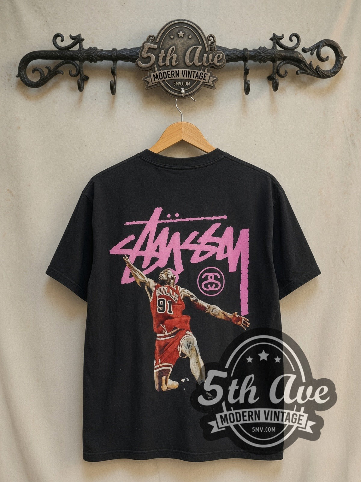 Dennis Rodman x Stüssy The King of Rebound vintage basketball tee in black, back view on a display rack
