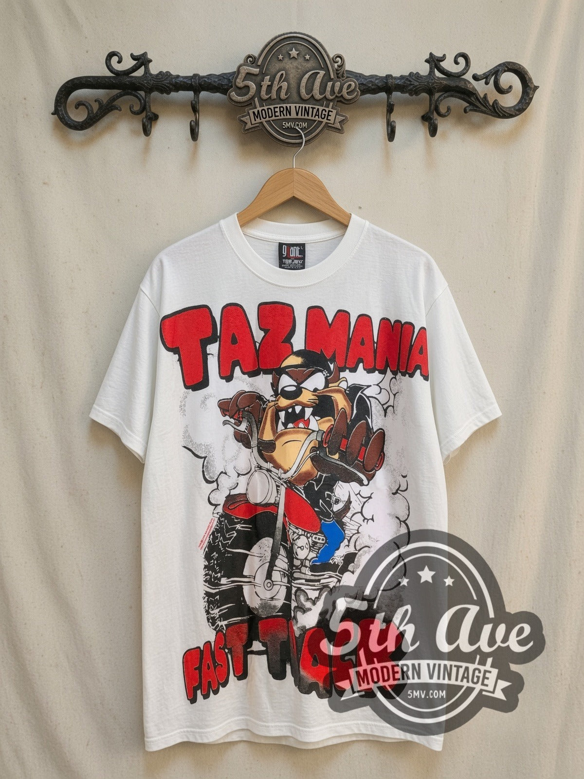 Looney Tunes Taz-Mania Fast Track all-over-print vintage cartoon tee, front view on a display rack