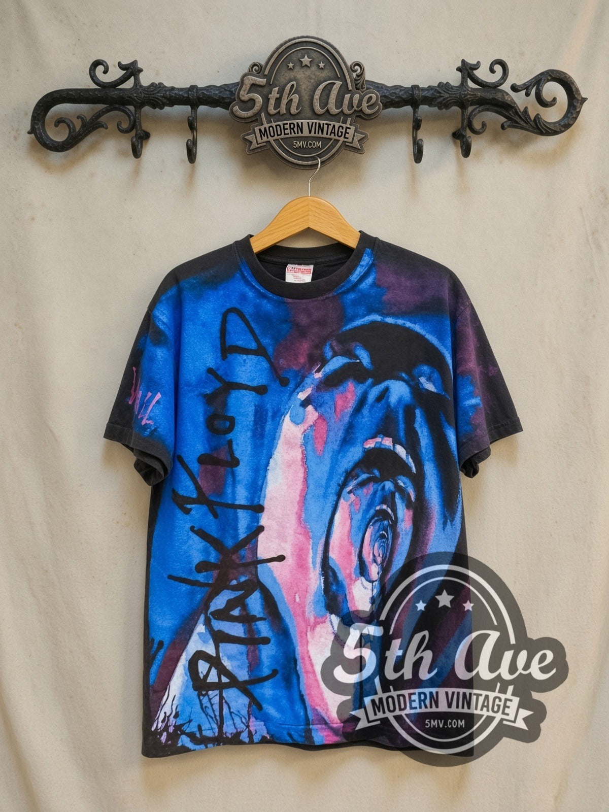 Pink Floyd The Wall Pink Blue Screaming Face all-over-print vintage band t-shirt in black, front view on a display rack